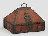 une vieille boîte en bois munie d'une poignée métallique, posée sur une surface blanche