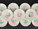 six white plates with pink and green designs on them on a black surface