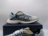 une paire de baskets bleues et grises posée sur une boîte