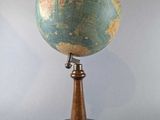 an old globe on a wooden stand with a white background