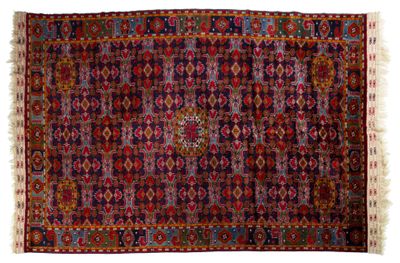 un tapis persan ancien aux motifs multicolores et aux franges