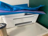 a printer sitting on top of a table next to a roll of tape