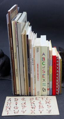 a black cat sitting next to a stack of books on a table