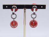 pair of red and silver earrings on a metal stand