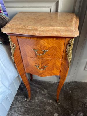 a small chest of drawers in the corner of a room
