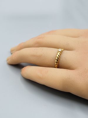 un gros plan sur la main d'une personne portant une bague en or
