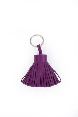 un porte-clés en cuir violet muni d'un anneau métallique et d'un pompon
