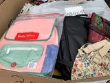 une boîte en carton remplie de nombreux vêtements et sacs