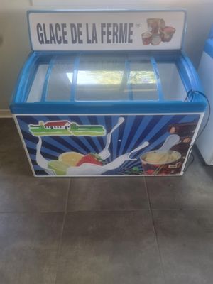 an ice cream machine sitting on the floor next to a refrigerator