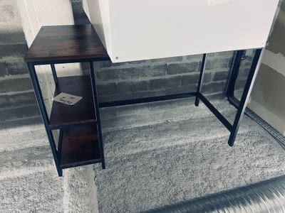 a small desk with a book shelf on top of it
