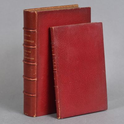 two red books sitting next to each other on a gray surface