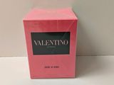 a pink box of perfume sitting on top of a white table
