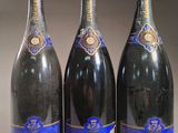 trois bouteilles de champagne posées sur une table l'une à côté de l'autre