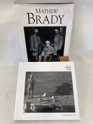 le livre est posé sur une table, à côté d'une photo représentant deux hommes