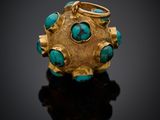 un gros plan sur une bague en or sertie de pierres de turquoise