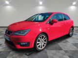 une voiture rouge garée sur le sol en damier d'un garage