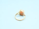 an image of a gold ring with an orange stone in the middle