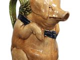 un petit cochon en céramique avec un nœud papillon autour du cou