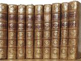 five books that are sitting on a wooden shelf