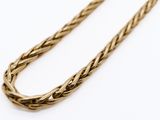 a close up of a gold rope necklace on a white background