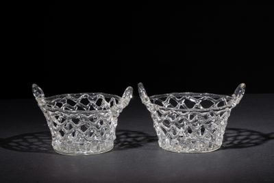 pair of crystal bowls with handles on a black surface