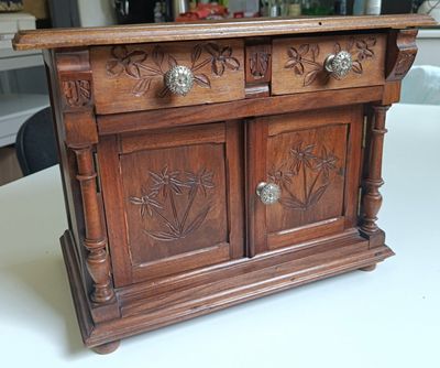 a small wooden cabinet on a table in a room