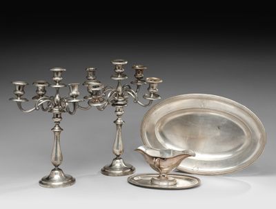 trois bougeoirs en argent et une assiette ornée d'un oiseau