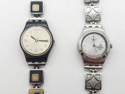 Deux montres sont posées côte à côte sur une surface blanche
