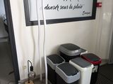 une photo d'une pièce avec des poubelles et une affiche accrochée au mur
