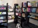 une bibliothèque noire remplie de livres dans une pièce