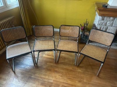 quatre chaises dans une pièce aux murs jaunes et au parquet