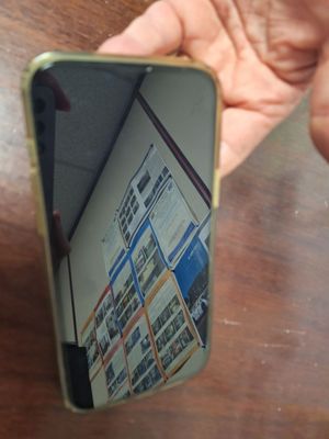a person holding a mirror with a picture of a building in it
