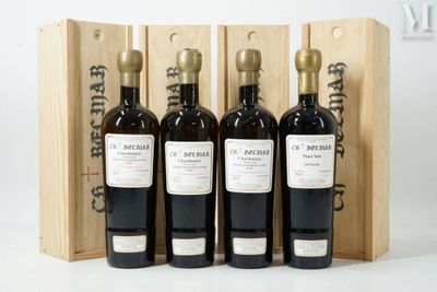 trois bouteilles de vin dans un coffret en bois sur une surface blanche