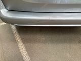 the rear end of a silver car parked in a parking lot