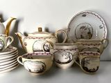 many cups and saucers and teapots on the table
