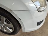 a close up of a white car with a denting on it
