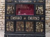 une armoire noire et dorée avec une porte en verre rouge