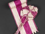 pink and white striped ribbon with a bow on a black background