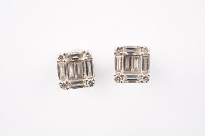 une image d'une paire de boucles d'oreilles en diamant sur fond blanc