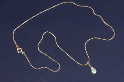 une photo d'un collier en or orné d'une pierre verte