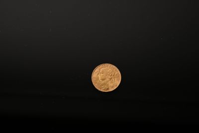 a close up of a gold coin on a black background