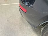 a car that has been dented and is parked in a parking lot
