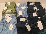 plusieurs paires de pantalons pour homme avec leurs étiquettes de prix encore attachées