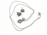 un ensemble composé d'un collier et de boucles d'oreilles posé sur une surface blanche