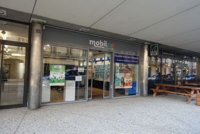 une photo d'une devanture de magasin avec un banc devant