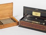 deux boîtes en bois contenant des cigares, posées sur une surface blanche