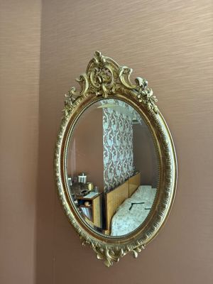 un miroir accroché au mur au-dessus d'un lit dans une chambre