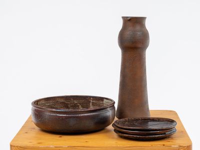 a brown vase and a bowl on a wooden table