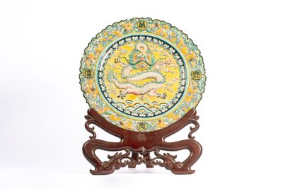 une assiette décorative ornée d'un dragon, posée sur un socle