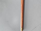 a wooden stick and a rock on a gray surface